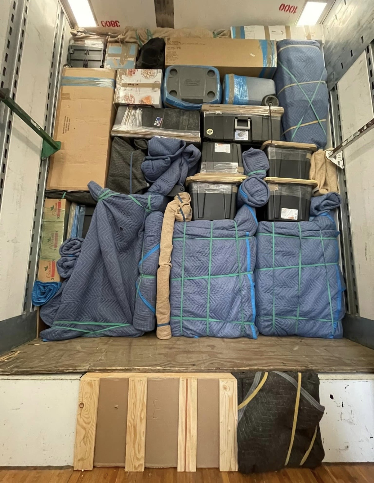 Neatly stacked boxes, bins and wrapped furniture ready for storage