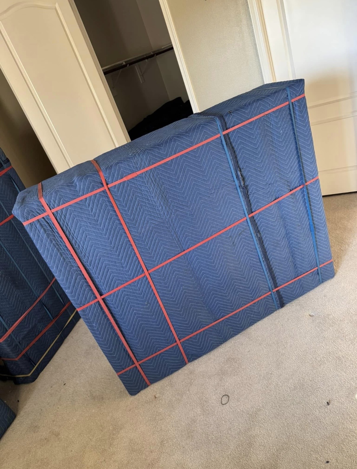 Furniture wrapped in moving blankets and secured with bands for commercial transport