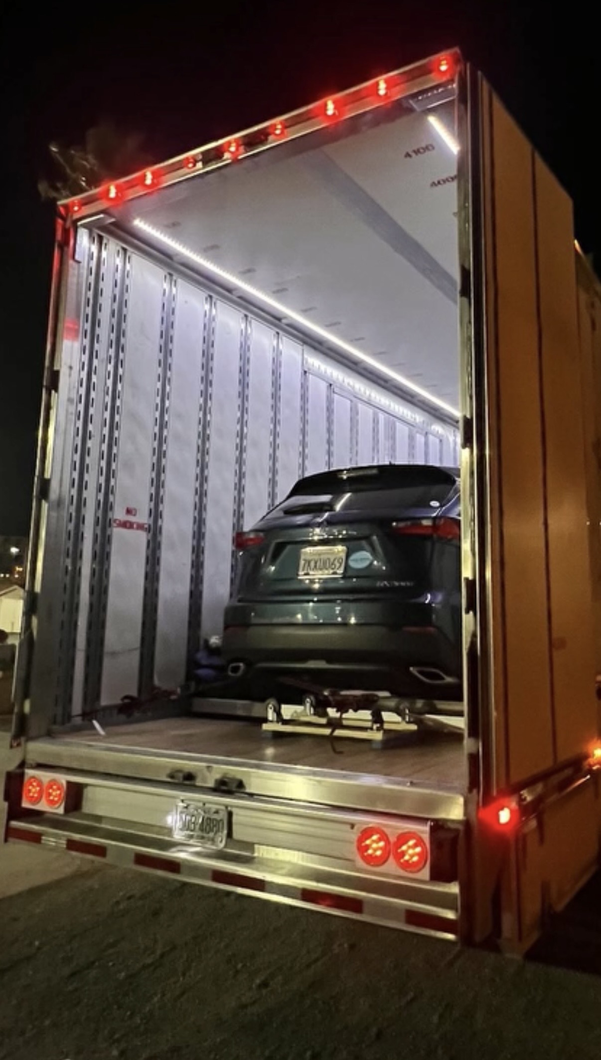 Customer's SUV secured inside an enclosed car-carrier trailer at night